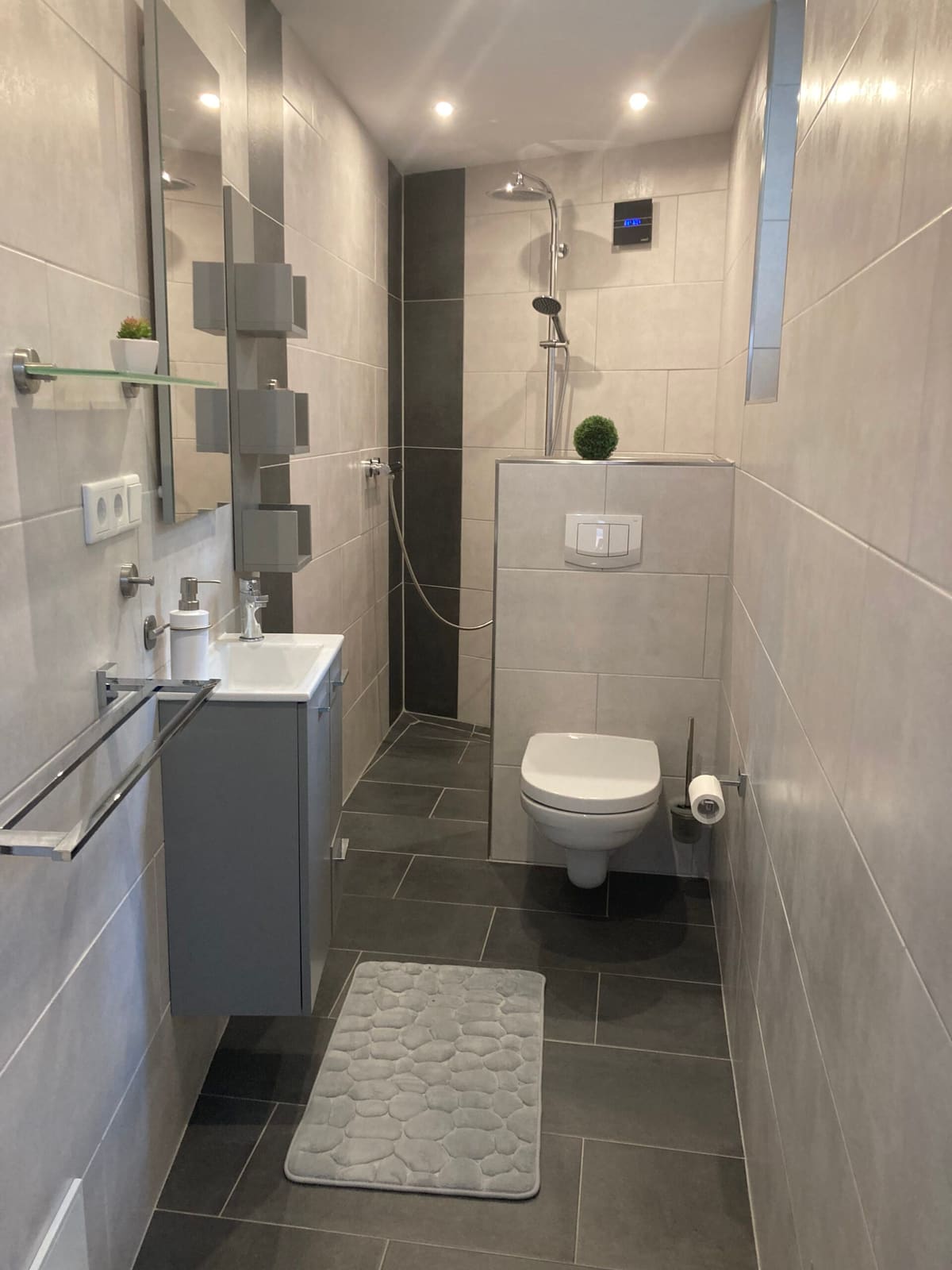 Helles Duschbad mit Glasabtrennung, Waschtisch und WC