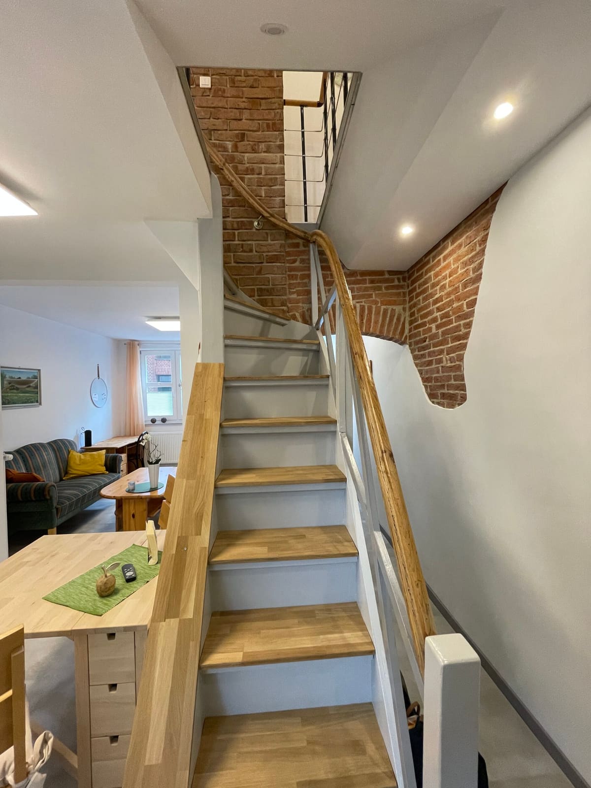 Holztreppe vor einer Wand aus rotem Klinker
